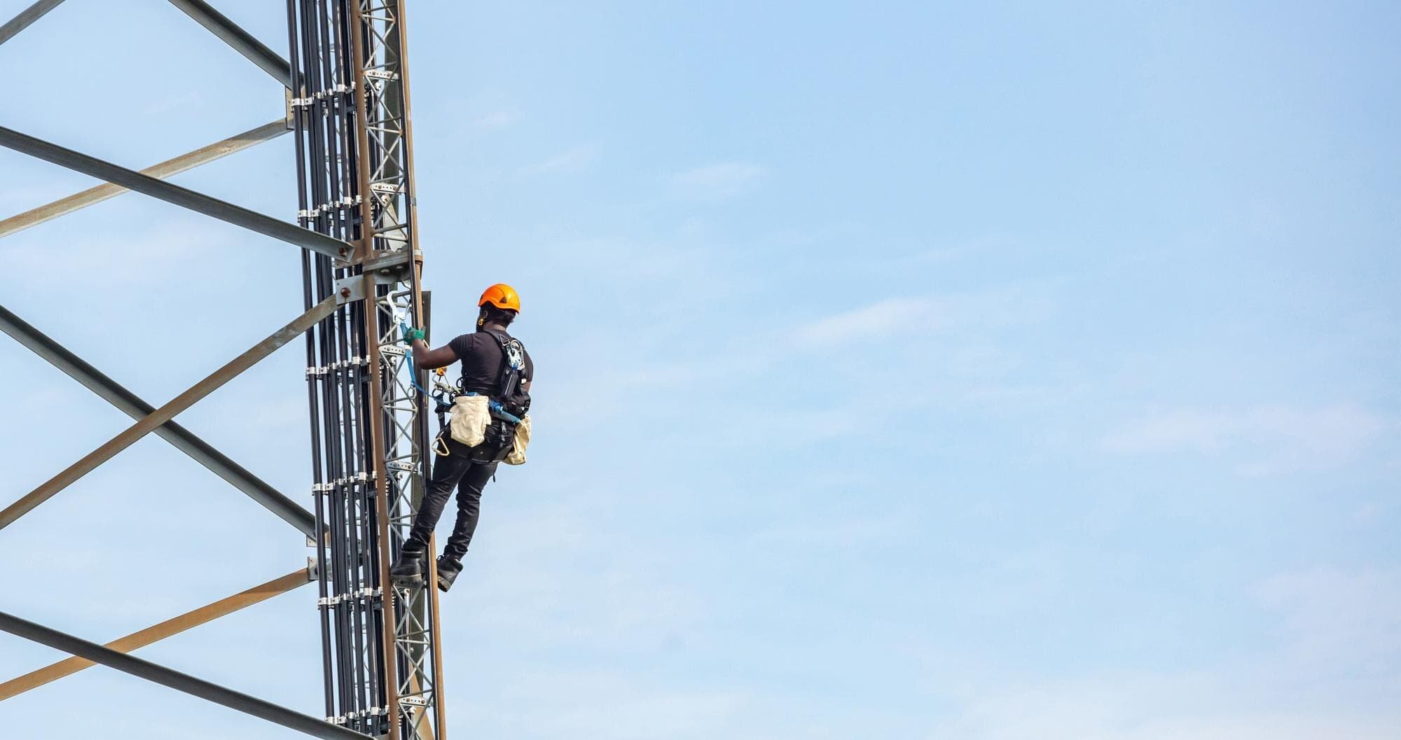 WZC technician installing a coverage antenna at sunset